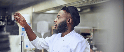 A chef decorating a plate