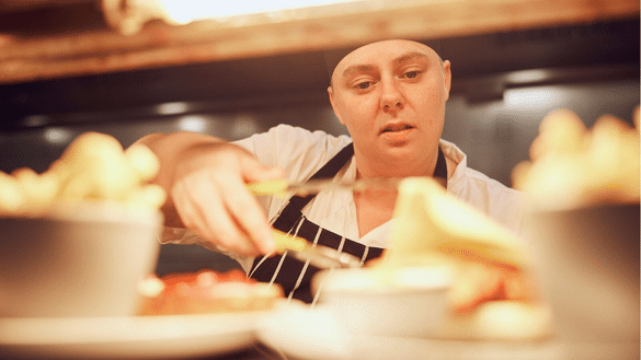 Chef plates up food in the kitchen